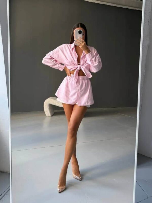 Modelka v dvojdielnej pásikavej letnej súprave s oversized košeľou a krátkymi šortkami na gumu.